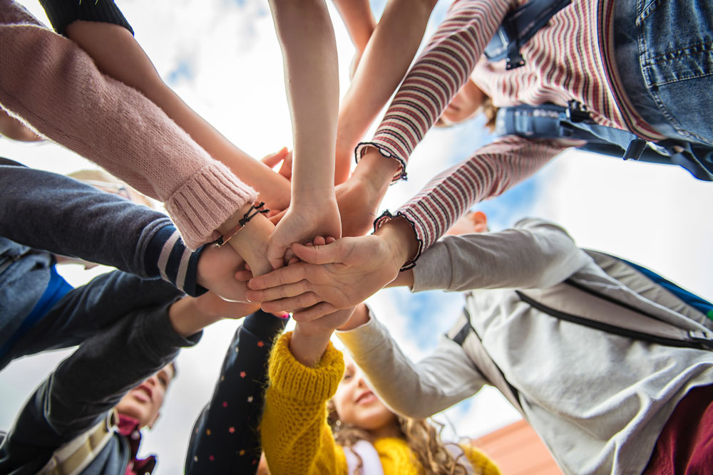 Kids in a circle with hands stacked