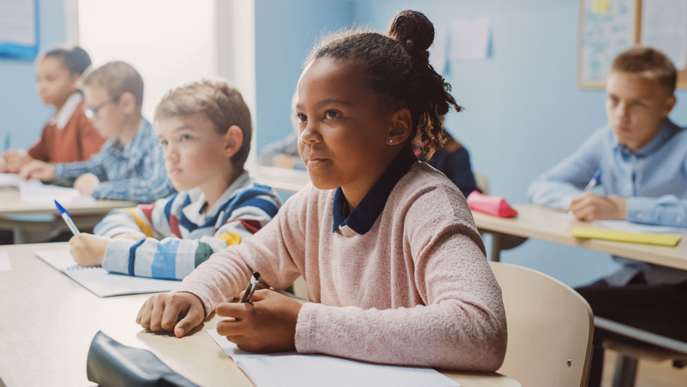 Middle school children at desks in classroom